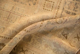 Visible knot heads and distressed texture on the vintage Oushak rug in muted beige.