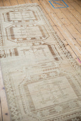 Heavy abrashes with faded geometric guls on the beige and brown Oushak rug.