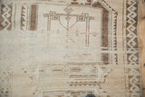 Oushak runner's distressed beige field, brown geometric motifs, and even worn pile.