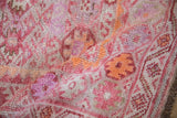 Folded distressed Kurd rug runner displaying abrash dusty fuchsia and pale tangerine guls.