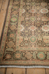 Vintage Sivas rug corner featuring green scrolling vines, floral blossoms, and dark ground.