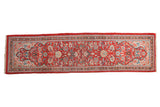Vintage Persian Arak rug runner with a dense floral pattern in brick red, sapphire blue, and ivory.