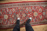 Vintage Persian Arak runner with dense floral blossoms on a brick red ground.