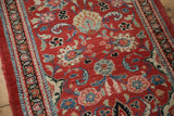 Hand-knotted pile of a vintage Persian runner showing floral motifs on a brick red field.