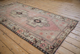 Distressed field and stepped medallion with germinating blossom motif on Oushak rug.