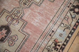 Textured dusty mauve field, geometric sand spandrel with ram horn tendrils on a vintage Oushak.