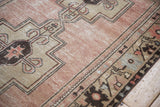 Distressed vintage Oushak rug border with ram horn tendrils and germinating motifs in dusty mauve, sand.
