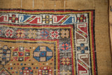 Corner detail of antique Serab rug with camel field, blue hexagonal medallion, and geometric serpent border.