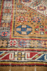 Antique Serab rug's camel field, featuring a blue geometric medallion and pinwheel floral motifs.