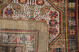 Antique Serab rug's foundation and side selvage, with worn camel, ivory, red, and blue geometric motifs.