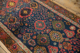 Vintage Bijar runner's intricate hand-knotted palmettes in navy, madder red, and gold.