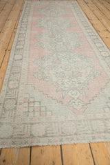 Distressed vintage Oushak runner detail: low pile shows dusty blush and antique ivory patterns.