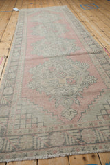 Vintage distressed Oushak runner, blush and silver hues, worn texture, floral border detail.