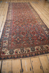 Angled view of a vintage Bijar runner with a faded brick red and blue Herati design.