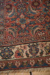 Close view of the vintage Bijar's brick red Herati field and detailed ivory floral border.