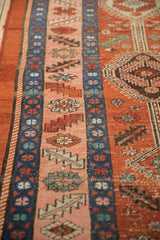 Angled detail of the Heriz runner's border in sapphire blue and pink, showing a textured, worn pile.
