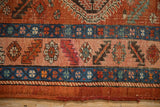 Serrated leaf and floral motifs on the worn, colorful border of an antique Persian runner.