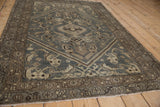 Angled view of a vintage Hamadan rug, showcasing its even wear, geometric medallion, and slate blue tones.