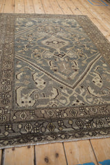 Angled view of a distressed Hamadan rug highlighting its even wear and traditional medallion design.