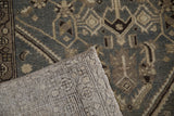 Folded corner of a vintage Hamadan rug showing its low pile and hand-knotted foundation.