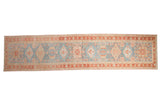 Vintage distressed Karaja runner with a column of geometric medallions in powder blue, dusty red, and blush.
