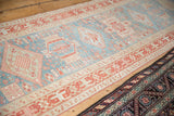 An angled view of a vintage Karaja rug runner styled next to another Persian rug.