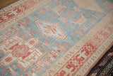 Even wear and low pile texture of a distressed Karaja runner with geometric motifs in red and blue.