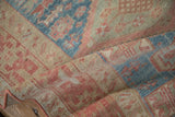 Time-softened texture of a distressed Karaja runner with geometric details in dusty cherry red and powder blue.