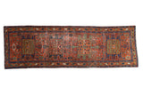 Antique Heriz runner with single column turtle medallions in brick red, navy, and jade green.