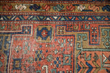 Antique Heriz runner detail: brick red field, geometric motifs, sapphire blue and ochre border.