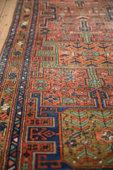 Antique Heriz runner's sapphire blue border and brick red field with geometric designs.