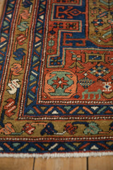 Antique Heriz runner's geometric border in sapphire blue, brick red, and a jade green blossom motif.