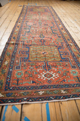 Antique Heriz runner detail: navy geometric border, brick red field, and visible knot head wear.