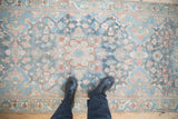 Distressed vintage Bakhtiari runner, with a soft blue and blush floral pattern.