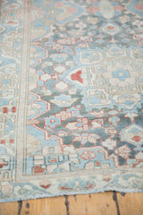 Distressed Bakhtiari runner showing textured pile, stylized floral motifs in blue and red.