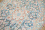 Patinaed field of a vintage Bakhtiari runner, with blue, pink, and ivory floral patterns.