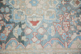 Distressed vintage Bakhtiari rug runner border in blue, blush, and rust traditional patterns.