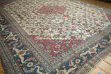 Corner of a Khorassan rug with its dusty navy Samovar Turtle border and ivory Herati field.