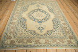 Vintage Tabriz rug corner with navy blue arabesques, beige field, and coffee brown border motifs.