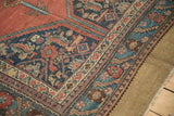 Antique Hamadan rug corner showing the serrated leaf border and textured, low-pile weave.