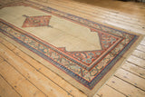 Long angle of an antique Serab runner showing its beige seeded lattice field and intricate borders.