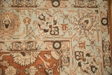 Corner of a vintage Tabriz rug with palmettes on the pale blue border and terracotta field.