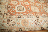 Angled view of the distressed Tabriz carpet's terracotta palmettes and contrasting pale powder blue border.
