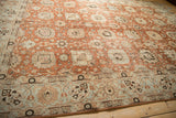 A low angle perspective highlighting the soft, time-worn texture of a vintage terracotta and blue Tabriz carpet.
