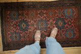 Vintage Mehriban rug with a raspberry red field and dusty blue hook-and-latch medallions.