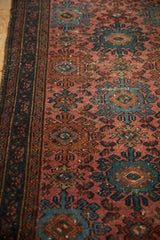 Mehriban rug: ribboned border, pale raspberry field, dusty teal hook-and-latch Mahi motifs.