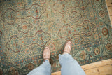 Dusty teal and dark copper tones on the geometric vine pattern of a distressed vintage Malayer rug.