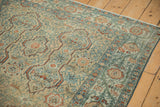 Elaborate serbend-style vine border on a distressed Malayer rug in teal and copper.