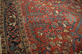 Meandering vine and Turtle Samovar border in navy, teal, and red on a vintage Heriz carpet.
