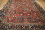 A vintage Heriz carpet's navy Turtle Samovar border alongside the red geometric field.